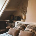 Inviting attic bedroom with boho style decor and plaid bedding in Andorra.